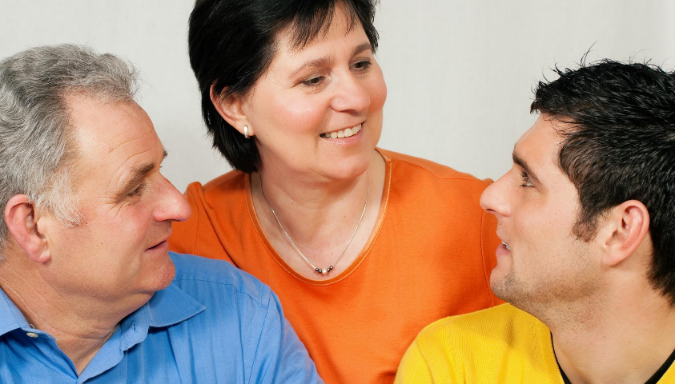 Image of three people, two males and one female looking at each other